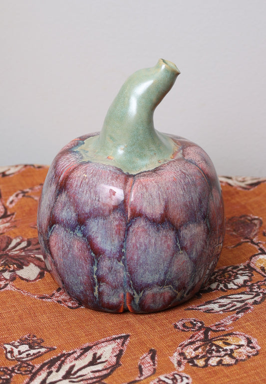 Rust and purple ceramic pumpkin with twisted stem.
